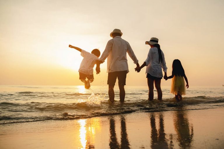 Family walking on the beach at sunset